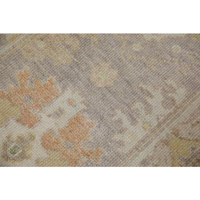 This modern Turkish Oushak rug is a stunning piece of art that has been handwoven using traditional techniques by skilled...