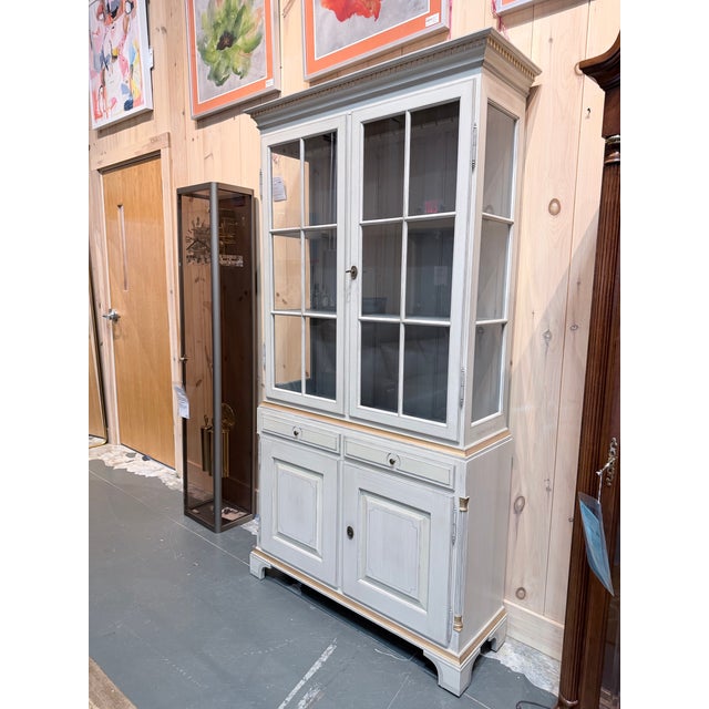 A refined Gustavian style display cabinet attributed to K.A. Roos of Helsingborg, showcasing a beautifully muted painted...