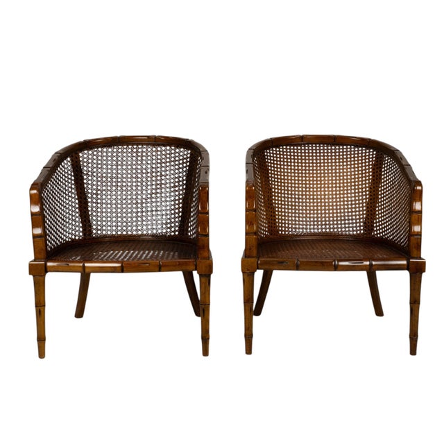 Beautiful pair of vintage faux bamboo barrel chairs with woven cane seats, backs, and sides. The curved frames and bamboo-...