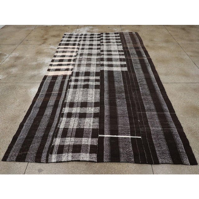 A vintage Turkish flatweave Kilim long and narrow room size carpet in charcoal black, grey, and cream-white, handmade...