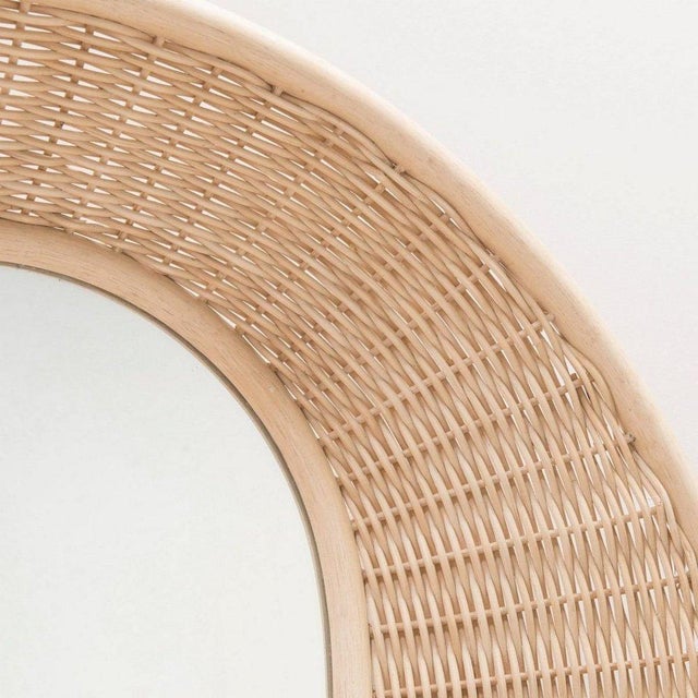 Large round mirror with a sculptural, woven rattan frame forming a basket, which can be hung vertically or horizontally....