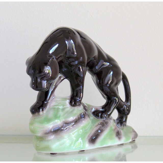 Make a bold statement with this striking 1950s Mid-Century Modern ceramic black panther sculpture, a timeless decorative...