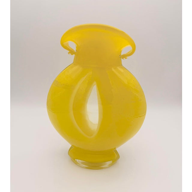 A striking hand-blown art glass vase in saturated canary yellow, featuring a voluptuous sculptural form and beautifully...