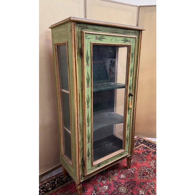 Venetian-style painted wooden display cabinet Three glass sides Decorated with ribboned foliage Spindle legs