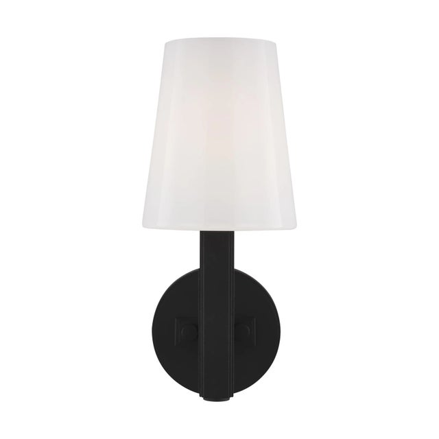 The Logan one light wall sconce features a tapered Milk White glass shade atop a slim arm set into a round backplate....