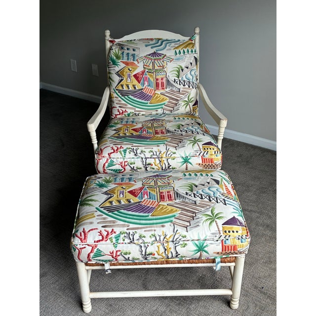 Chic vintage coastal lounge chair and matching ottoman featuring a beautifully refinished cream-painted frame with hand-...