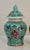 Vibrant trio of miniature lidded porcelain jars from Jingdezhen, each hand‑painted in rich turquoise, yellow, and...