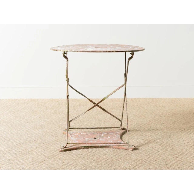 Folding iron bistro table mounted on iron base. Multiple paint layers. France, Circa 1875