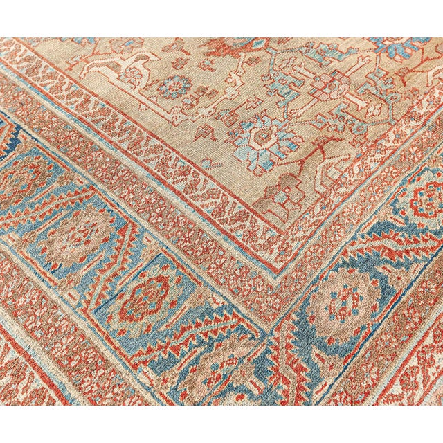 A hand-knotted wool antique Persian Bakshaish size adjusted rug dating back to circa 1880. The main field features florals...