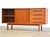 A mid century modern teak credenza with two sliding doors, two adjustable shelves and four drawers. Professionally...