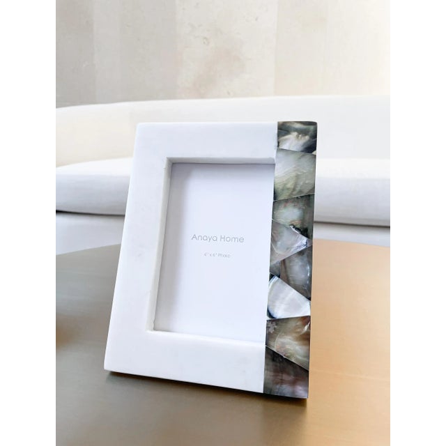 The Grey Mother of Pearl White Marble Picture Frame hold a 4x6 photo. The Genuine Mother of Pearl stripe accent has a...