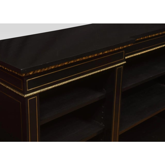 19th Century ebonized and gilt mounted open bookcase the large rectangular inverted breakfront top, over an ornate gilt...