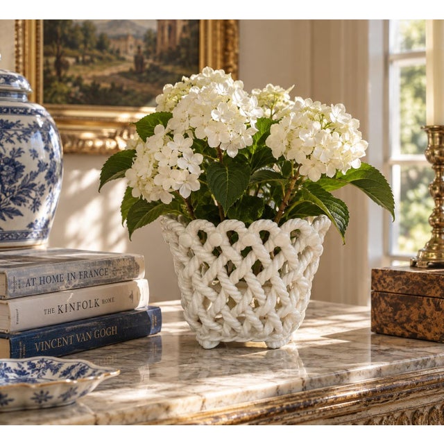 An elegant trompe l'oeil porcelain cachepot crafted in the form of a handwoven rope basket. Executed in glossy white...