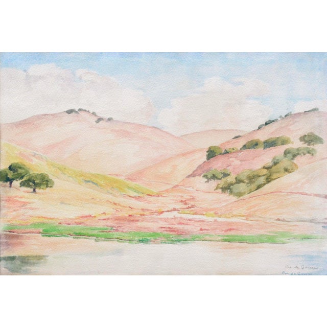 Vibrant California landscape consisting of pink and gold rolling hills, oak trees, and a body of water in the foreground....