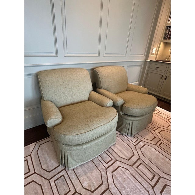 Elegant pair of upholstered club chairs featuring a timeless silhouette with gently sloped arms, plush loose seat...