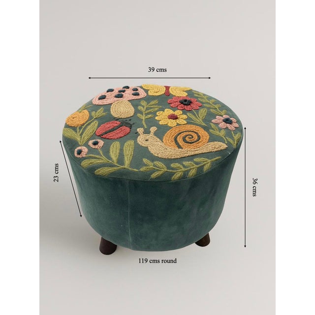 Bring a touch of playful charm to your living space with the Whimsical Garden Embroidered Footstool. Crafted in a rich...