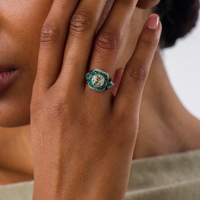 This extraordinary Art Deco style engagement ring is a bold contemporary jewel inspired by the symmetry, color, and...