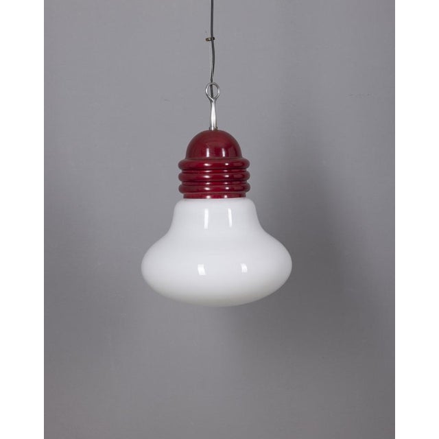 Red metal pendant lamp with a large white glass shade, adjustable height. Designed by Piero Brombin for Artemide, 1970s. I...