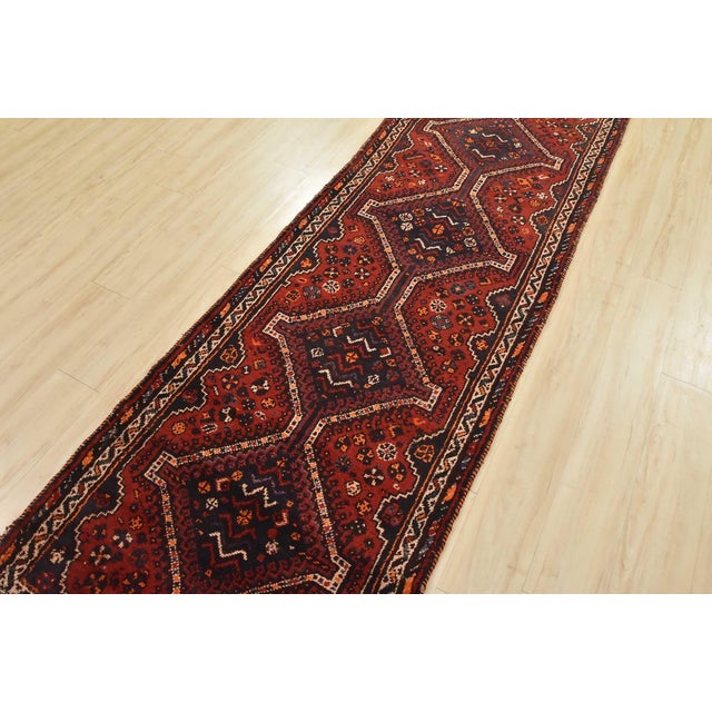 An authentic vintage tribal Shiraz runner hand-knotted with fine wool and natural dyes. This nomadic oriental rug features...