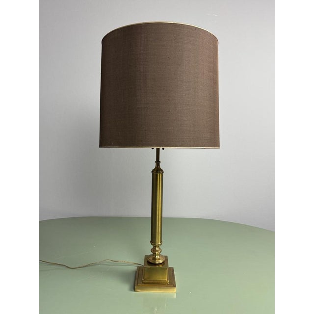 Elegant and imposing vintage Hollywood Regency table lamp featuring a beautifully proportioned solid brass column on a...