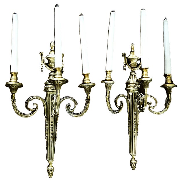 An elegant pair of french louis xvi-style wall sconces, expertly crafted in solid bronze and featuring a refined three-...