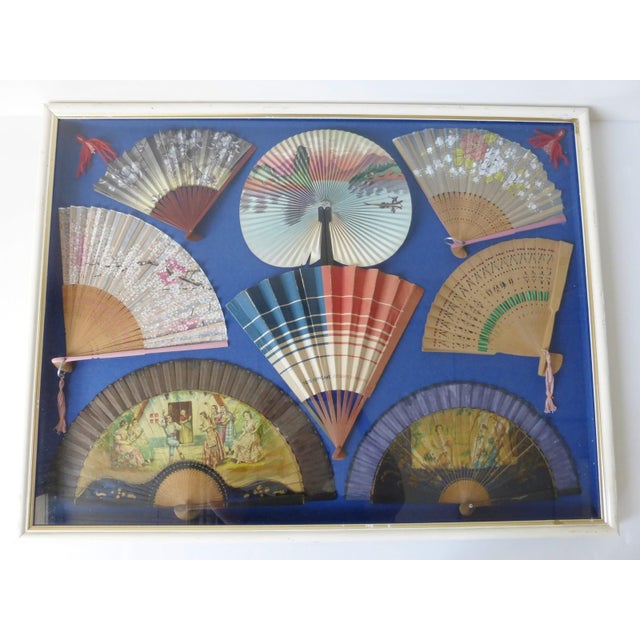 Decorative frame under glass displaying a collection of 8 vintage fans. Good condition, with normal signs of wear. There...