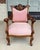 This Victorian walnut armchair features a carved crest rail with scrolling floral details, graceful scroll arms, and...