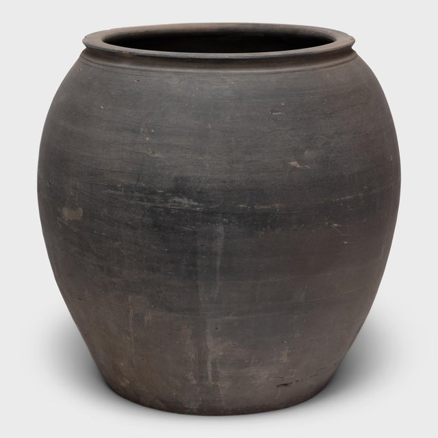 Sculpted during the early 20th century in China's Shanxi province, this clay vessel has a smoky grey exterior with...