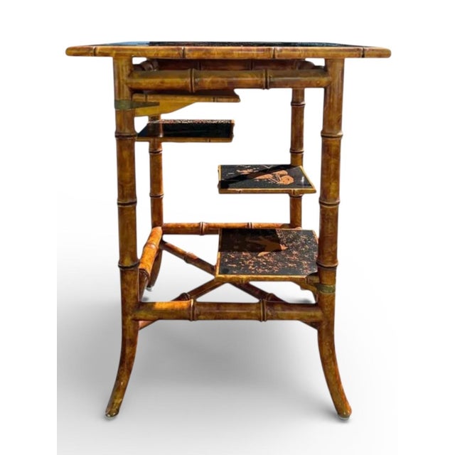 This is a reproduction bamboo and lacquer chinoiserie fern stand or side table. It has four shelves that rotate to support...