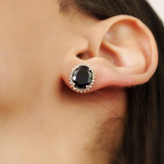 These elegant stud earrings are crafted in 925 sterling silver and feature stunning natural Iolite gemstones at the...