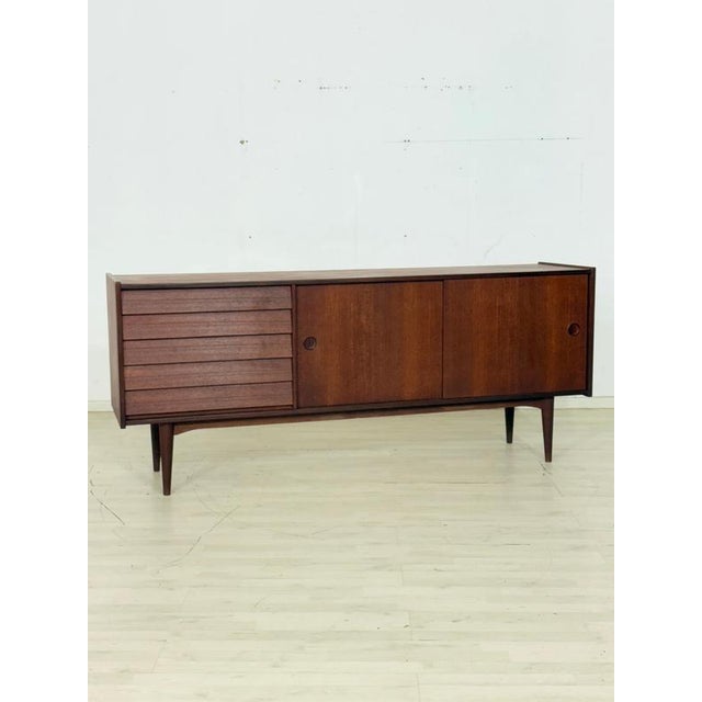 For sale is this elegant mid-century sideboard made of fine solid wood, stylishly combining timeless elegance and superb...