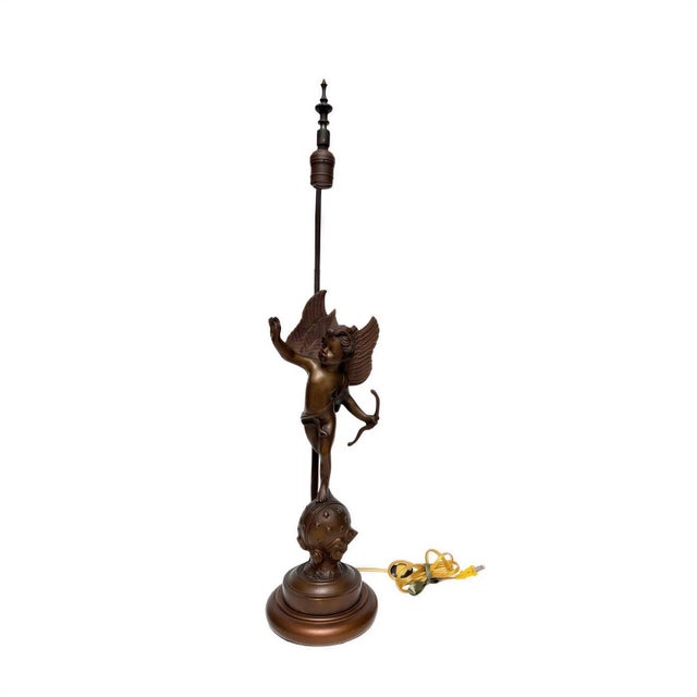 1980s Spanish bronze figural table lamp depicting a neoclassical winged Cupid holding a bow, standing on a star-embossed...