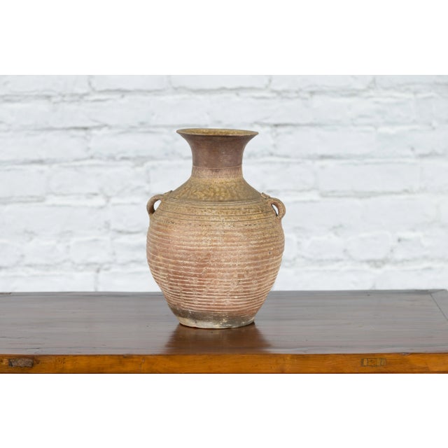 A Chinese Qing Dynasty period terracotta water vessel from the 18th century or earlier, with wavy motifs, concentric lines...