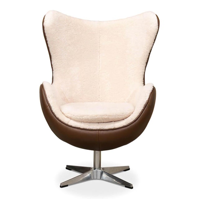 A sculptural shell recalls Arne Jacobsen's mid-century seating. Real shearling sheep's wool lines the interior, while...
