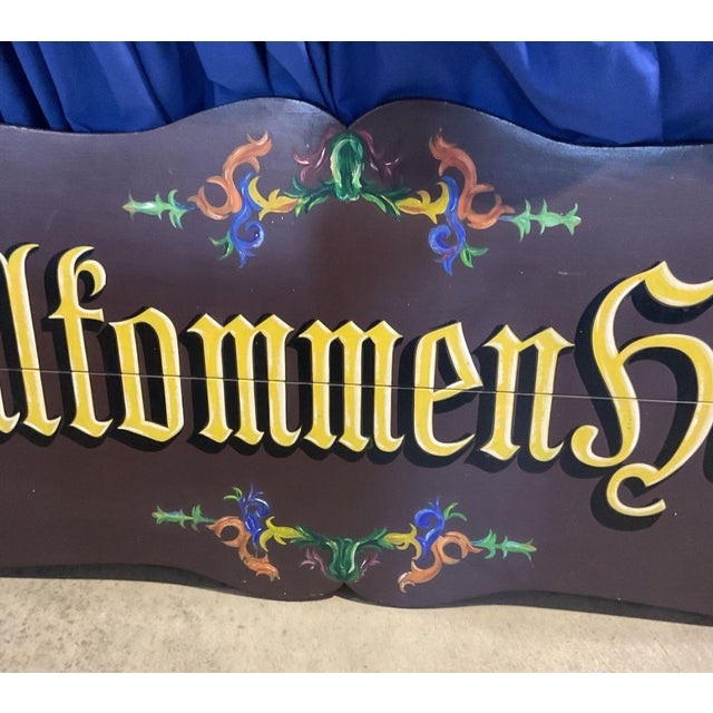 A magnificent and monumentally scaled vintage hand-painted wooden welcome sign featuring the traditional German greeting...