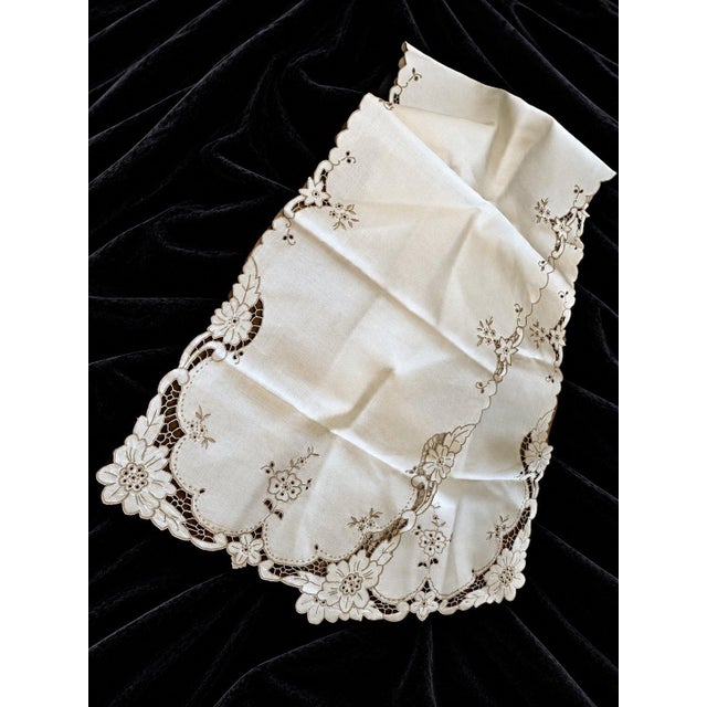 A beautiful vintage-style table linen set featuring delicate floral embroidery, intricate cutwork, and charming scalloped...