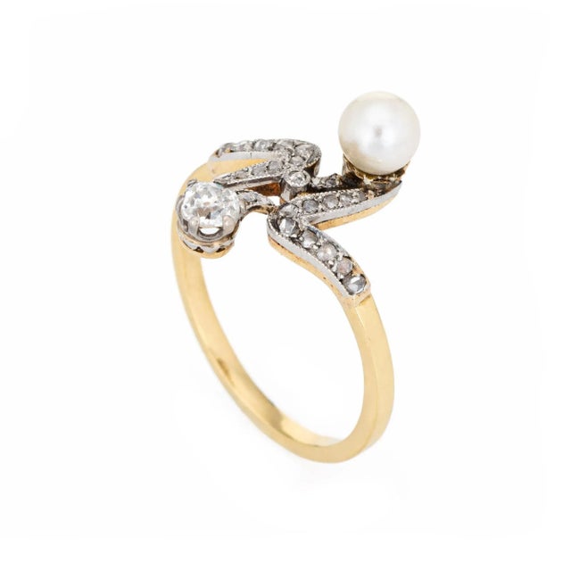 Finely detailed antique Edwardian diamond & pearl ''moi et toi'' ring crafted in 18k yellow gold (circa 1910s). The old...