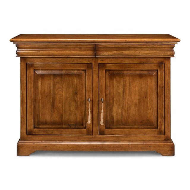 Raised door panels and a crown-molded top give the walnut case a restrained architectural outline. Nothing about the case...