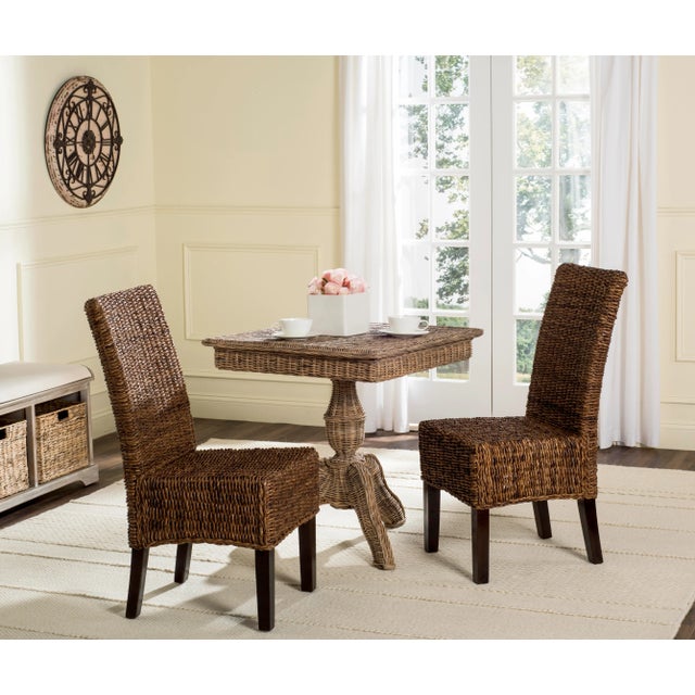 Crafted with exotic banana leaf fiber for it's brown coloring and shading, this set of two woven dining chairs is at home...