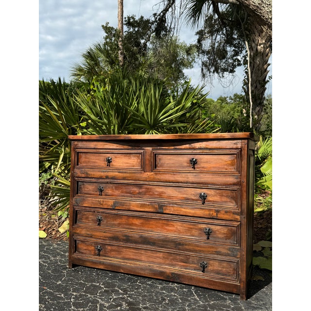 Beautiful British Colonial-style chest of drawers crafted entirely from heavy, solid wood with a warm, rich brown finish...