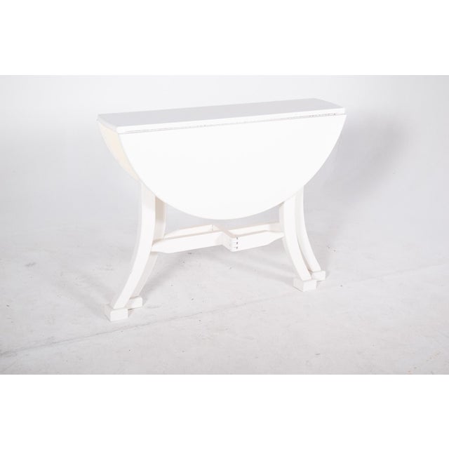 Flap table painted white. The two hinged flaps can be lifted to adapt the size of the surface as required, leaving a round...