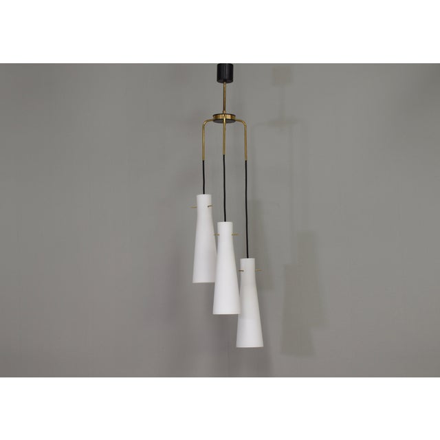 Elegant three spot pendant with opaline glass shades and brass details – Italy, circa 1950. Designer: Unknown...