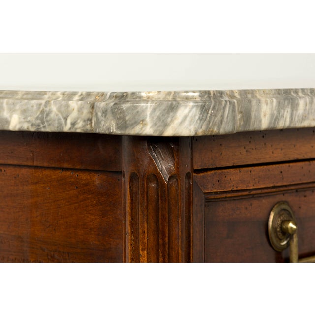 A late 18th-century French Louis XVI secrétaire à abattant crafted in walnut and topped with a gray and white veined...