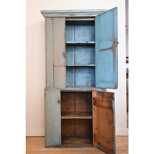 An American primitive "Stepback Cupboard". Lots of storage! Original blue paint is muted and rich with patina on the...