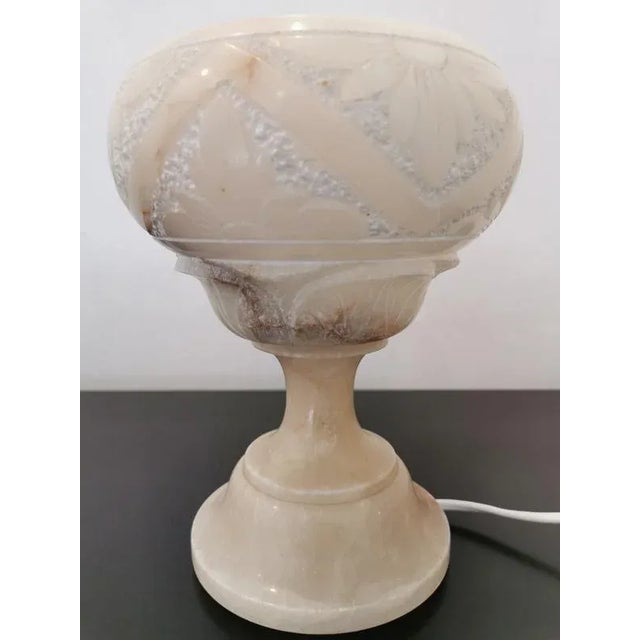 Lamp lamp in alabaster. Floral motifs carved in relief and a polite part. Some color difference in alabaster in darker...