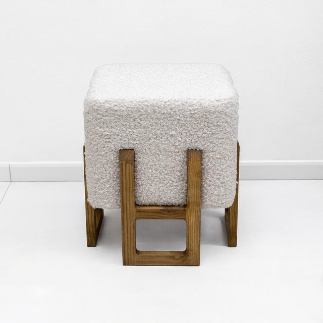 Elegant pair of sculptural stools featuring geometric ash wood frames with a warm honey-toned finish. The bases are...