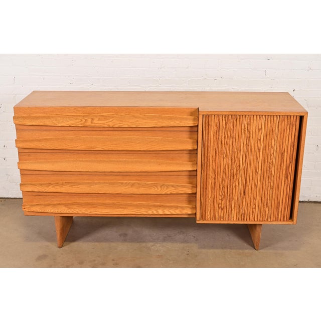 A gorgeous Mid-Century Modern sculpted oak tambour door sideboard, credenza, or dresser By Harold Schwartz for Romweber...