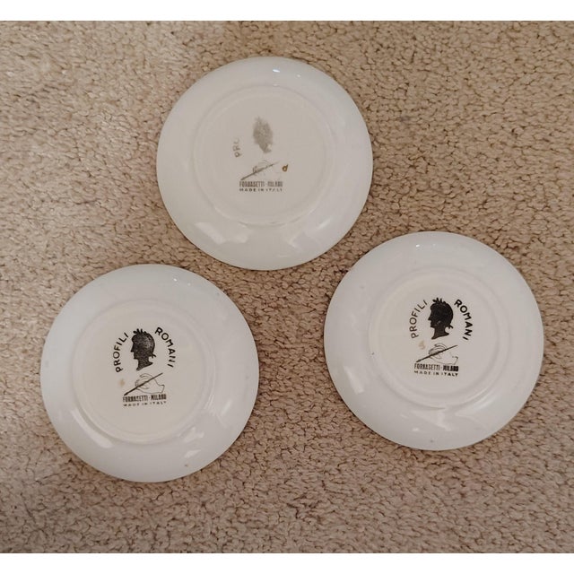 Piero Fornasetti "Profili Romani" set of 3 gold guilt ceramic coasters/small plates. The are all signed by the...