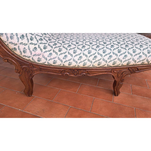 NINETEENTH CENTURY (1800 - 1900) Italian mid-19th century walnut daybed decorated with floral carvings. Side armrest....