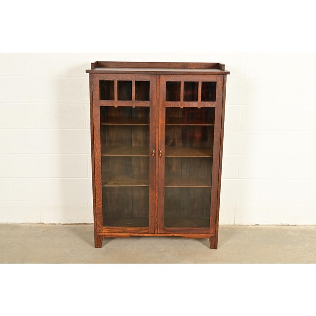 A beautiful antique Mission or Arts & Crafts period glass front bookcase or display cabinet In the manner of Charles P....